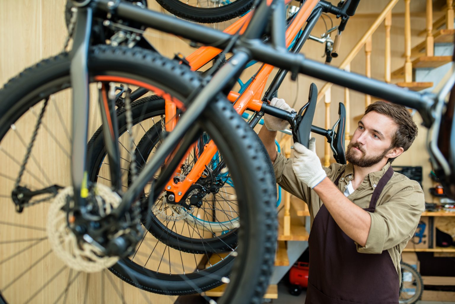We tell you the 9 ways that cyclists have to troll a bicycle shop ... - Storyblocks Waist Up Portrait Of ConcentrateD Young Mechanic In Apron ADjusting SaDDle Height While Working At MoDern Bicycle Repair Shop RpQmQTQbM 1 1536x1025